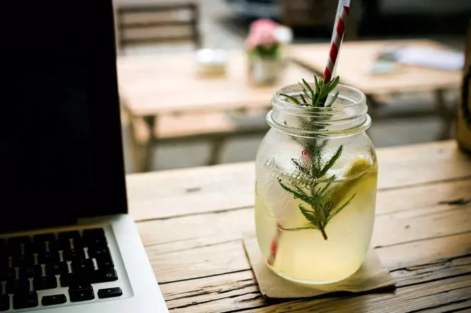 Homemade lemonade and laptop on table in a cafe