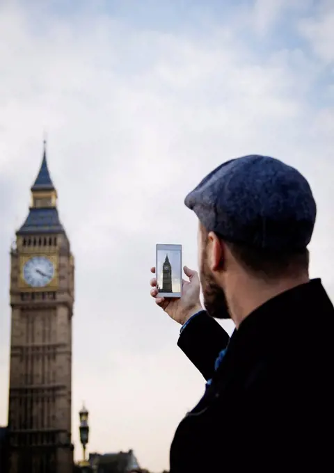 UK, London, man taking picture of Big Ben