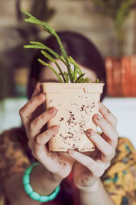 Young woman holding freshly potted cactus