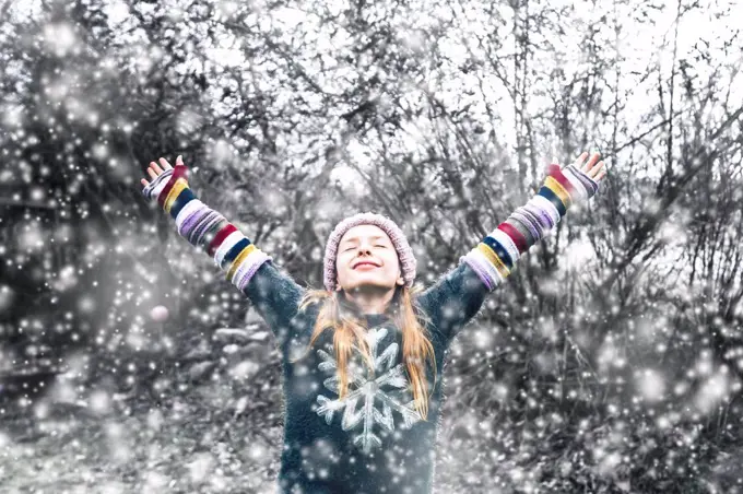 Happy girl at snowfall