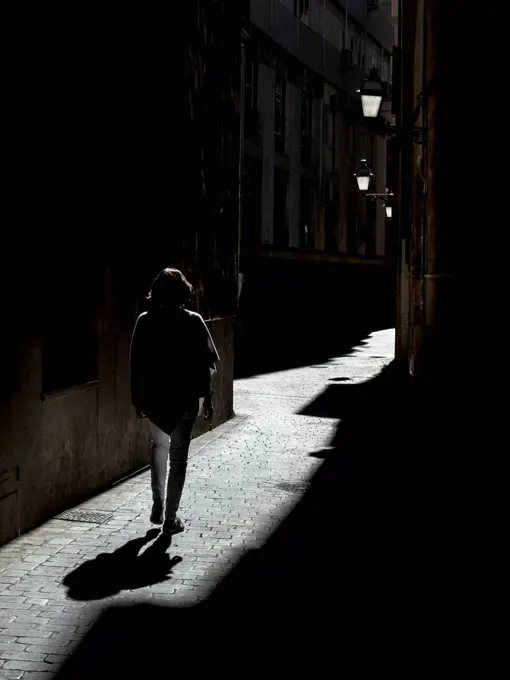Spain, Palma de Mallorca, woman walking in alley
