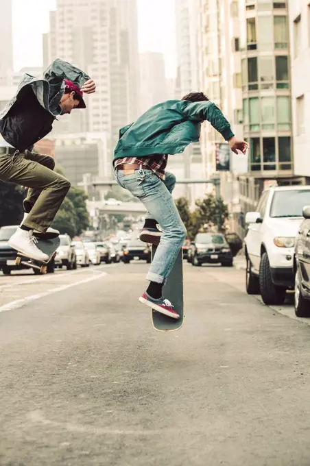 USA, California, San Francisco, two young men skating on the street