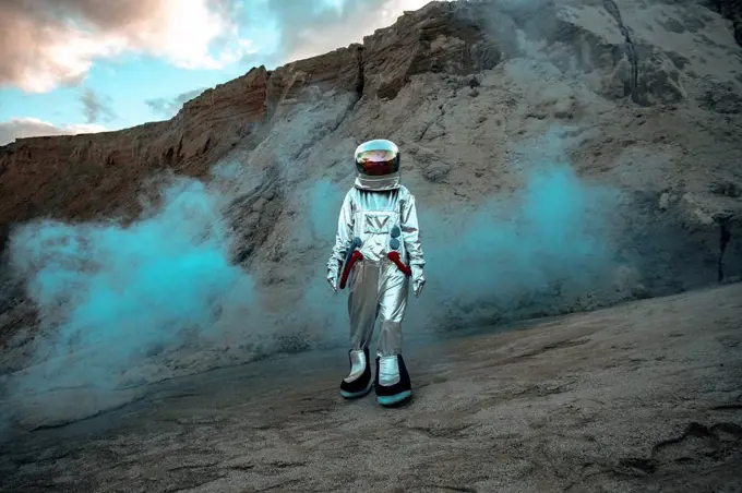 Spaceman exploring nameless planet, walking in a dust cloud