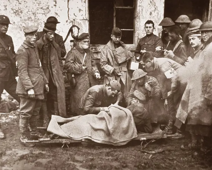 Lieutenant C.S. Darley, a Catholic chaplain, treating German officer lying on Stretcher outside Building, 89th Division Dressing Station, near Remonville, France, U.S. Army Signal Corps, November 2, 1918