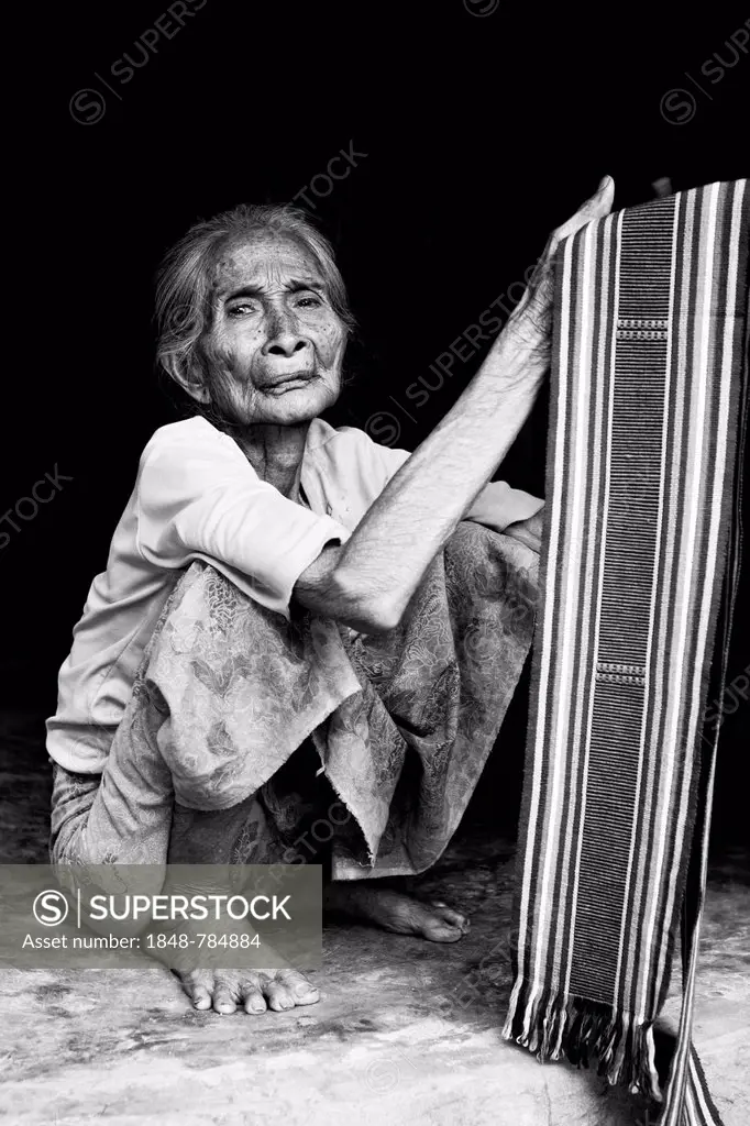 Elderly Indonesian woman selling fabrics