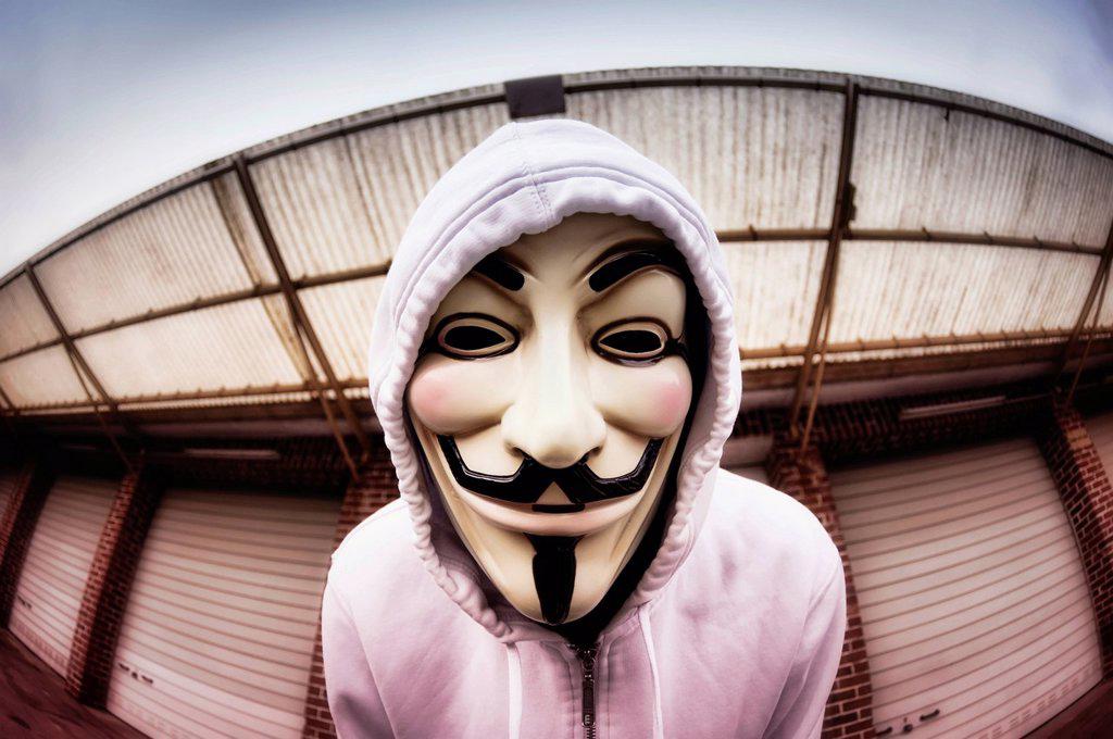 Man wearing the Guy Fawkes mask used by the Occupy movement, protesting against the power of banks