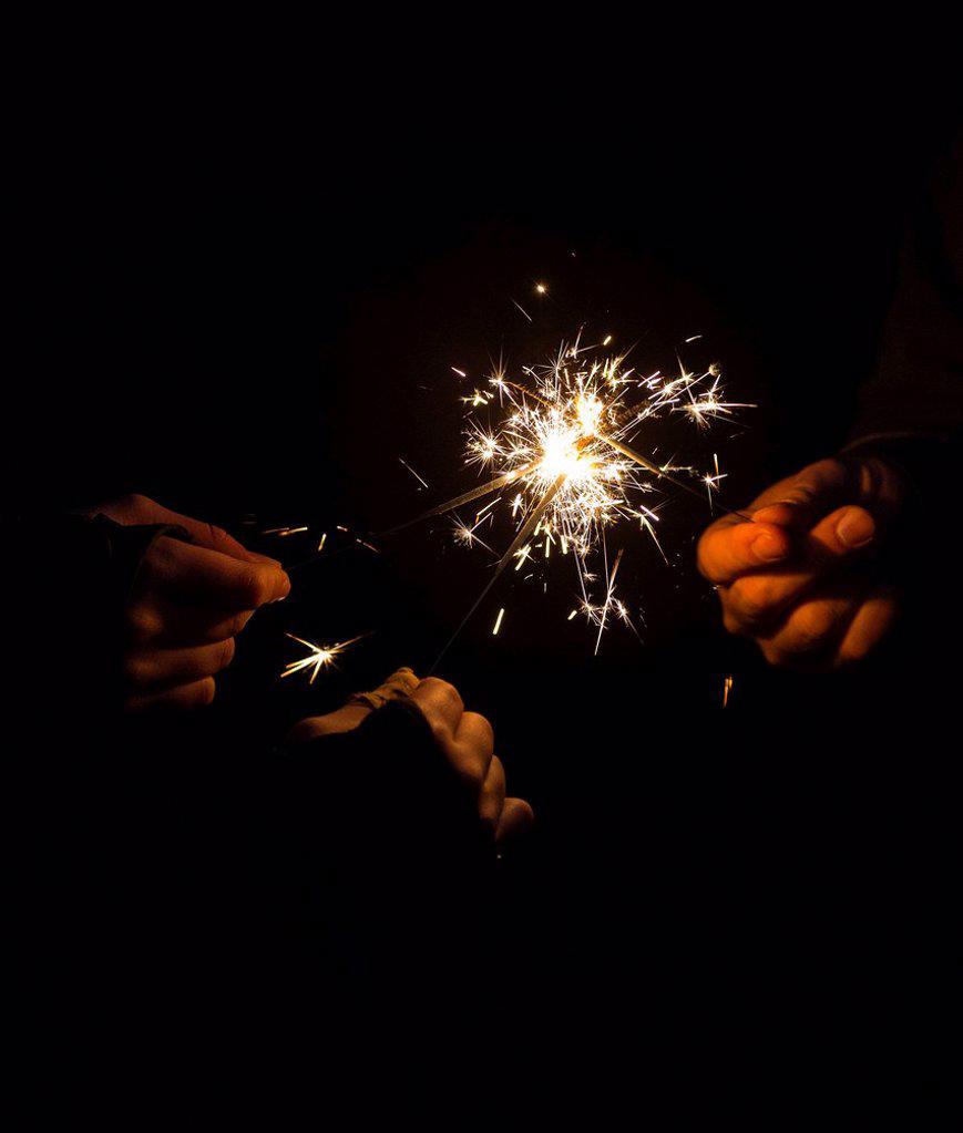 Burning sparklers in hands, symbil image party, fireworks, New Year's Eve