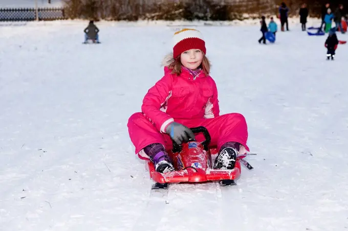 Girl sitting on a sled, Baden Wuerttemberg, Germany