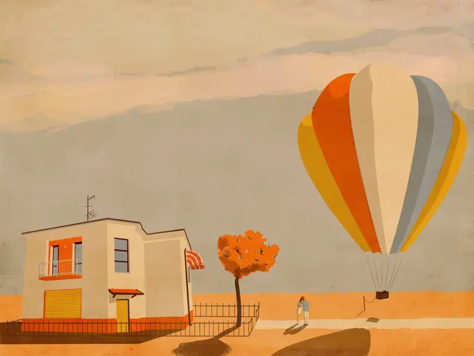 Couple hugging goodbye beside tethered hot air balloon