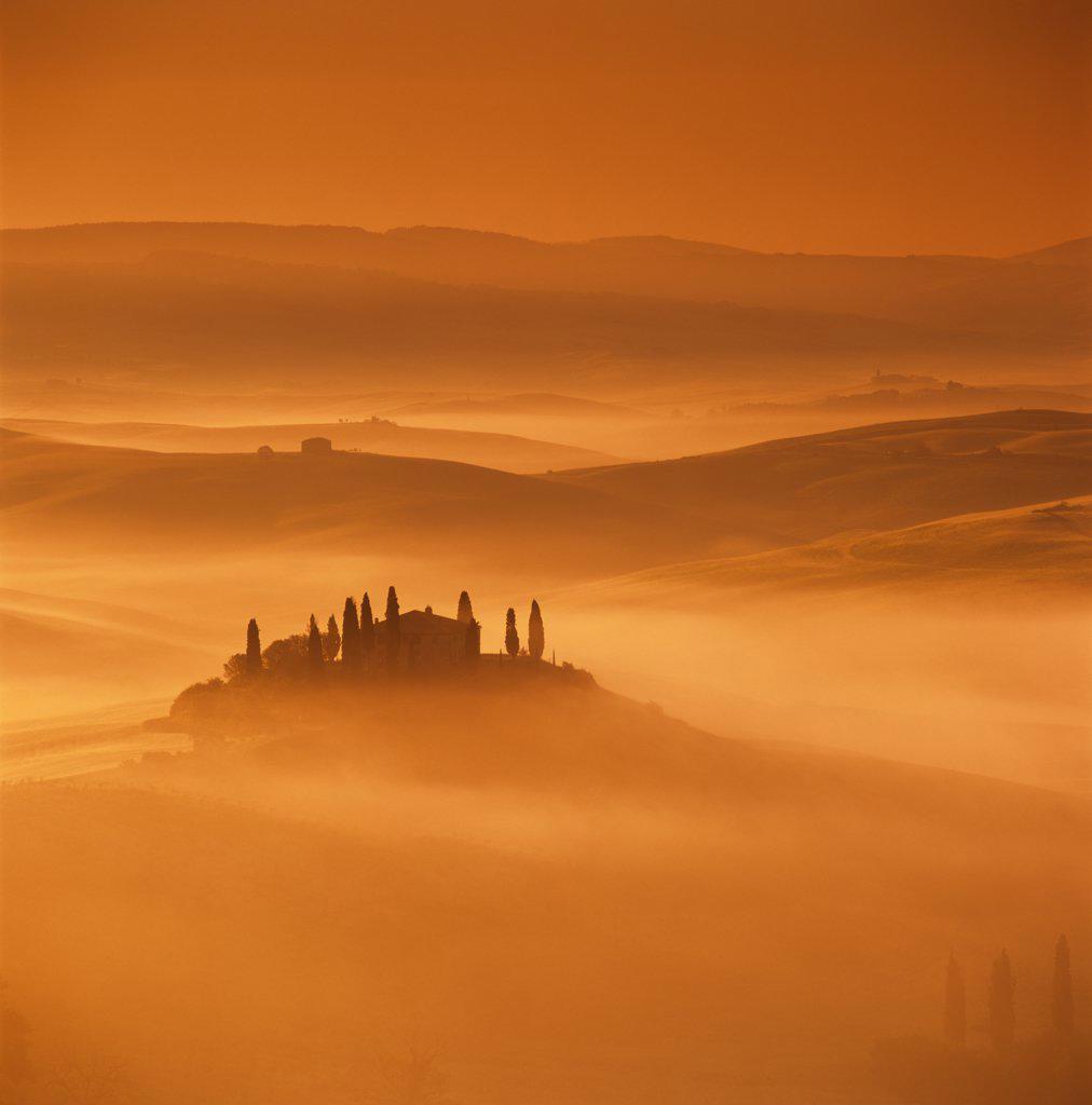 Tuscan farmhouse with cypress trees in misty landscape at sunrise, San Quirico d'Orcia, Siena Province, Tuscany, Italy, Europe