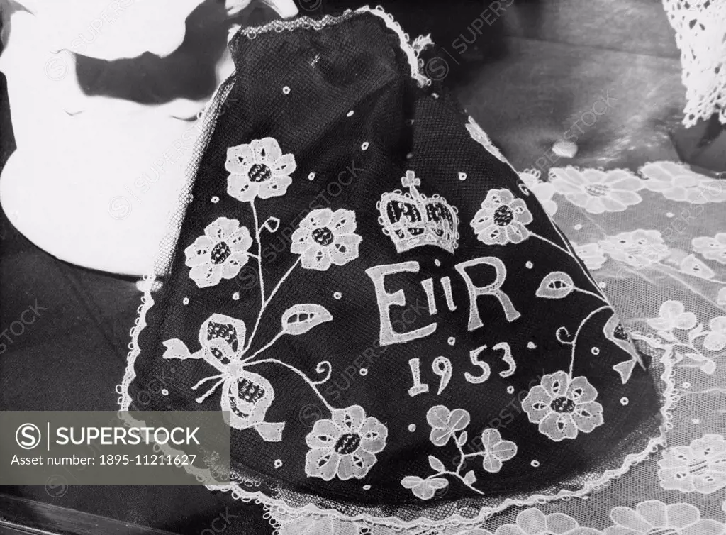 Lady's evening handbag in carrickmacross (Irish) lace on a black background with the wording ER 1953 worked into the pattern. The handbag was seen in ...
