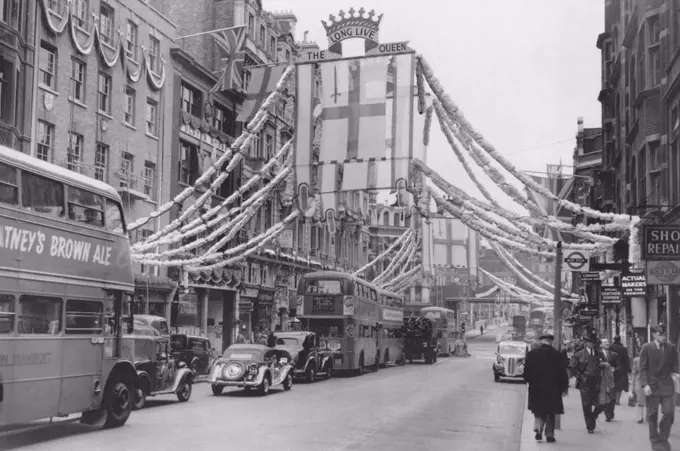 Fleet Street goes gay overnight. The vista of coronation gaiety with greeted city workers in Fleet Street, London. The decorations had appeared overni...