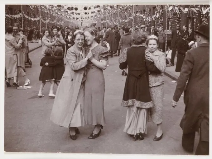 A snapshot photograph of people dancing in the streets of Bootle, Liverpool, taken by an unknown photographer in about 1937. This street party is prob...