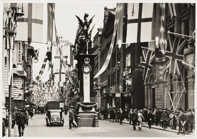 A photograph of Temple Bar in Fleet Street, London, taken by an unknown photographer in May 1937. The street is decorated with flags and bunting to ce...