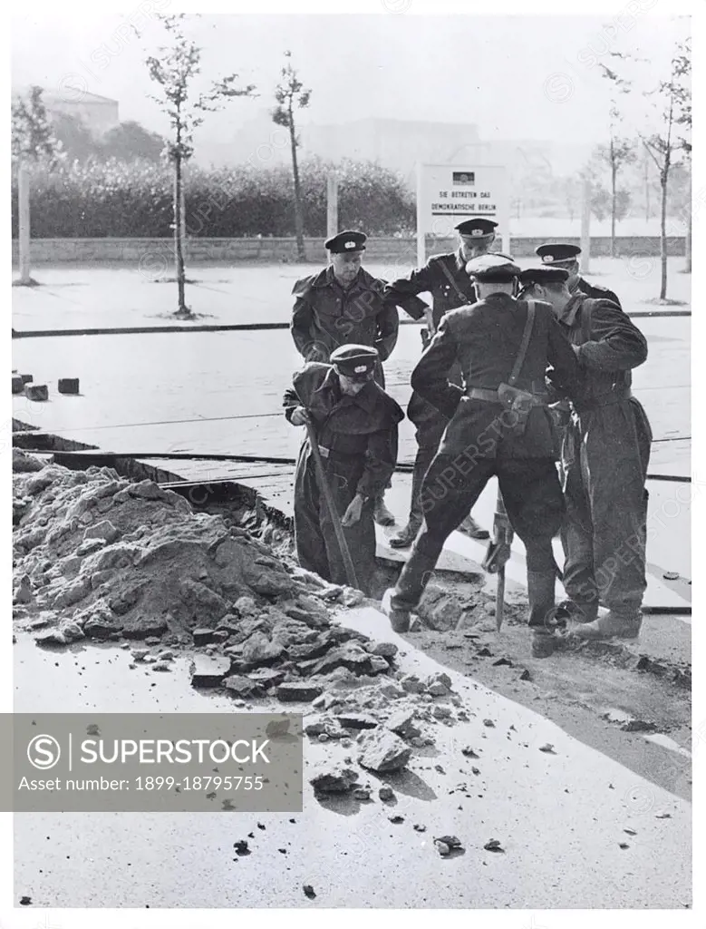 Berlin Wall Photo -  Date - Possibly August 1961 - East German Police Tear Up Pavement Near Potsdamerplatz to Build Permanent Road Block. Communist Erected Sign In Background Reads: 'You Are Entering Democratic Berlin.'. 