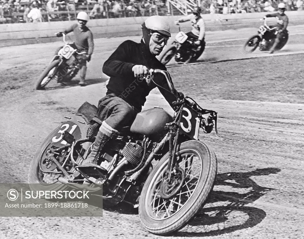 A grim-faced motorcycle racer skids through a turn as he leads the field on a "figure 8" race track, Los Angeles, CA, 1949. (Photo by United States Information Agency/GG Vintage Images)