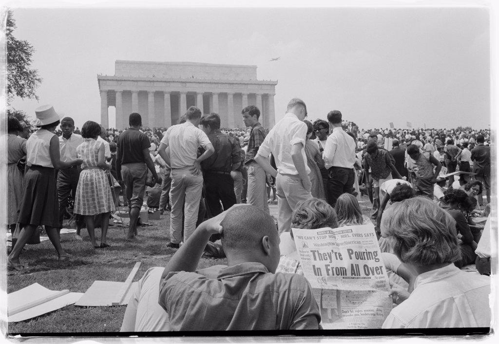 Two people at the March on Washington for Jobs and Freedom read the headlines about the crowds attending the event. (GG Vintage Images/UIG)