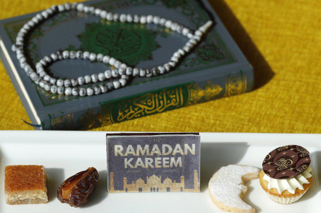 Holy Quran book with rosary and date and pastries. Ramadan concept.  Dubai. United Arab Emirates.