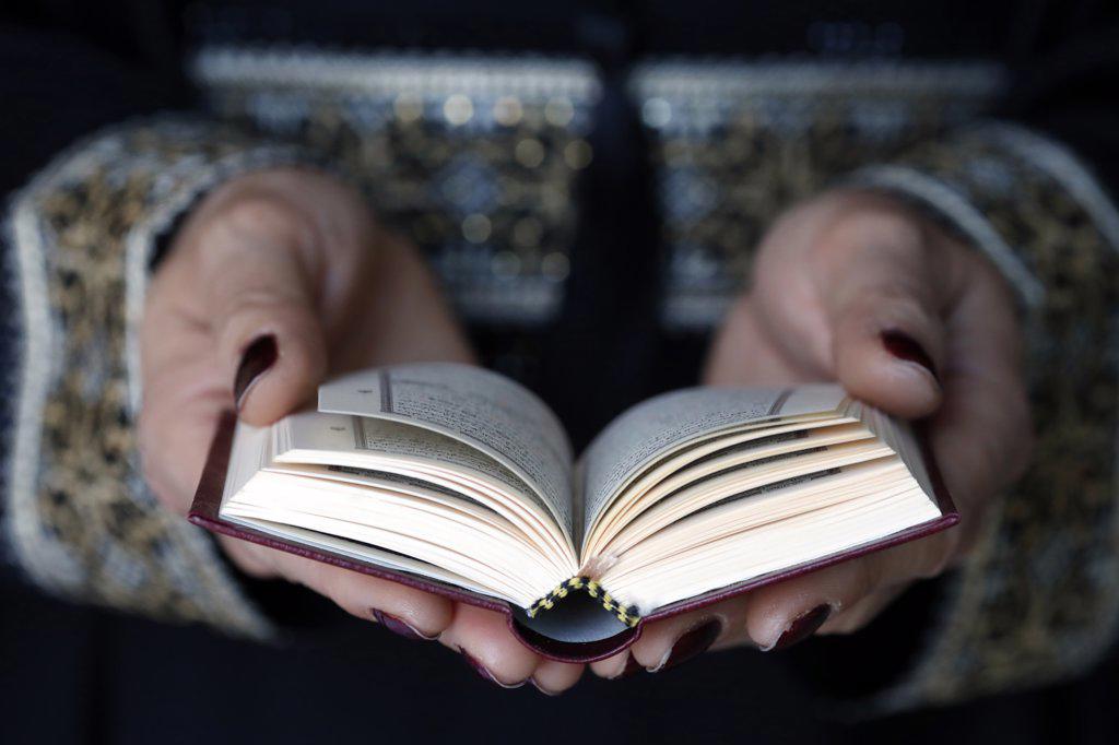 Muslim woman reading the noble Quran. United Arab Emirates.