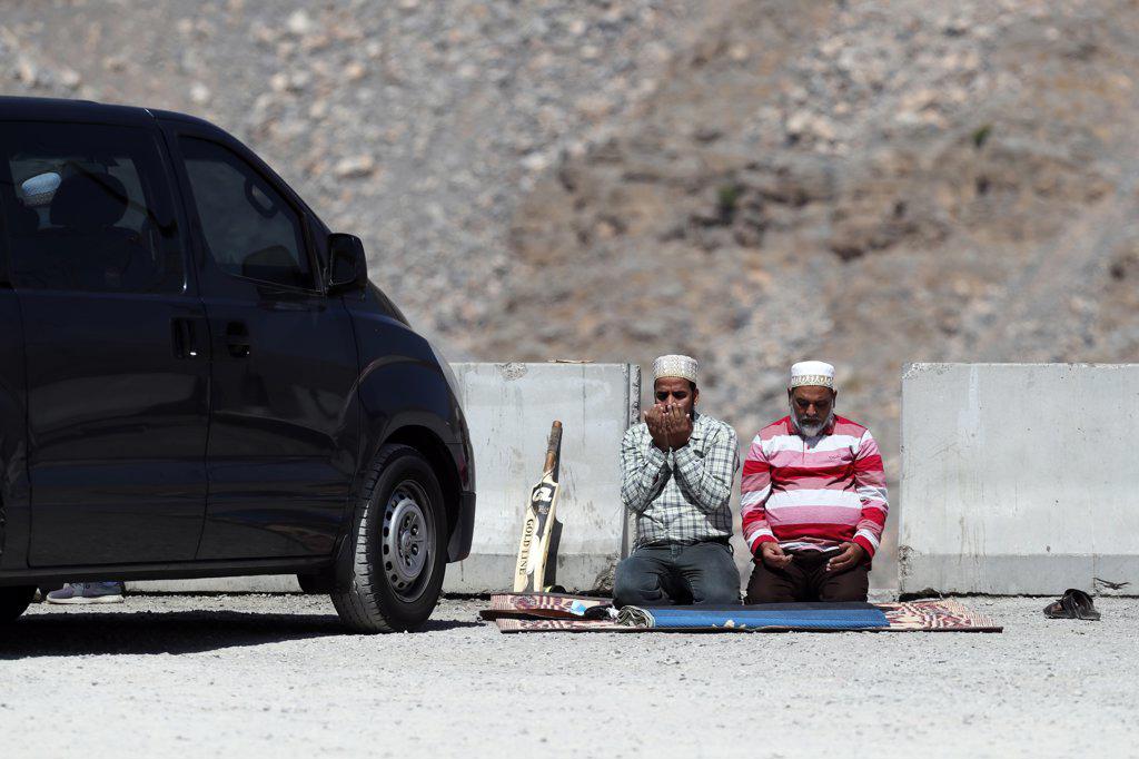 Muslim men performing salah during ramadan.   Jebel Jais. United Arab Emirates.