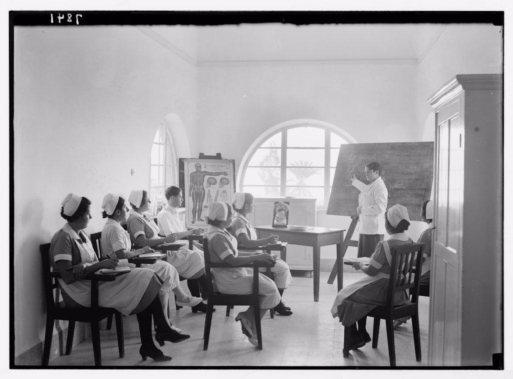 Teacher pointing to chalk board at Scots Mission Hospital in Tiberias Israel. Hospital nurses in class instructed by Dr. Little. ca. between 1934 and 1939.
