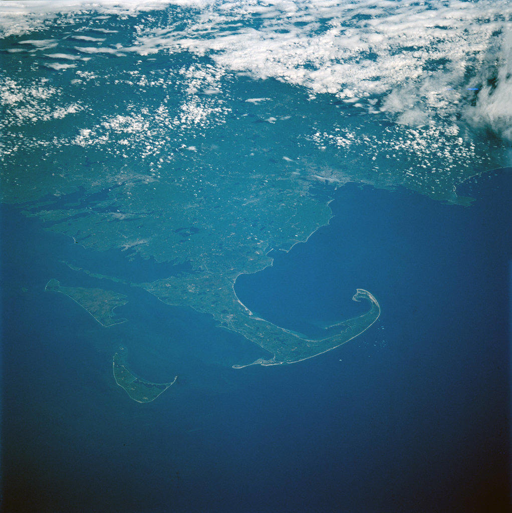 (15-24 May 1997) --- Cape Cod extends 105 kilometers (65 miles) into the Atlantic Ocean.  To the south of Cape Cod are the islands of Martha's Vineyard (west) and Nantucket (east).  The city of Boston can be seen surrounding the bay above the 'hook' on Cape Cod.  To the south are the cities of New Bedford on Buzzards Bay, and Providence, Rhode Island.  The Cape Cod Canal is an artificial waterway that connects Buzzards Bay and Cape Cod Bay.  The waterway is 28 kilometers (17.5 miles) and does not contains locks.  The canal was built to shorten the distance over water between New York City and Boston.  In 1620 the Pilgrims landed at Provincetown, on the upper tip of Cape Cod, before they proceeded to Plymouth.. 