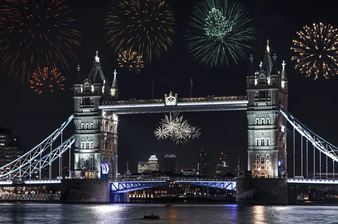 Londons Tower Bridge on the river Thames at night with fireworks being launched in celebration