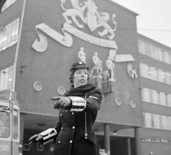 Female police officer arranges traffic for police headquarters / Date October 28, 1963 Location Amsterdam, Noord-Holland.