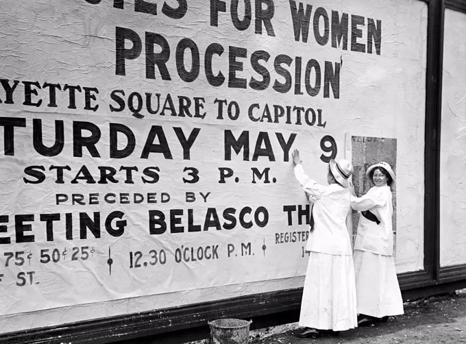 Woman suffragettes posting billboard poster circa 1914.