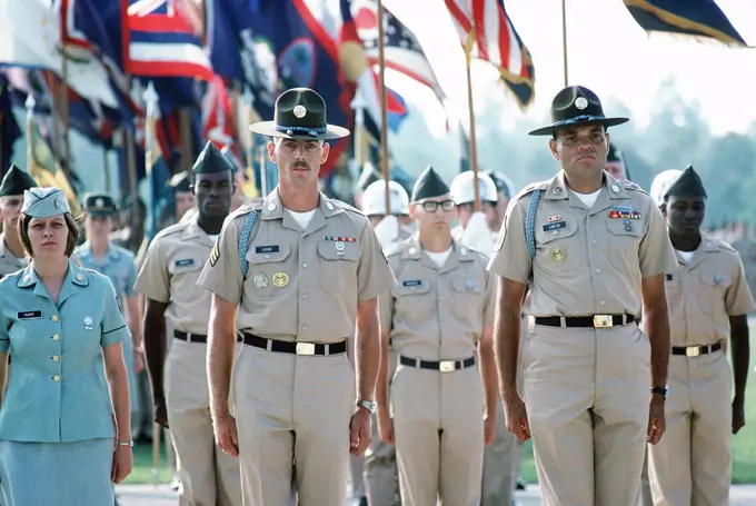 1977 - US Army drill instructors lead a formation of troops on the parade ground. 