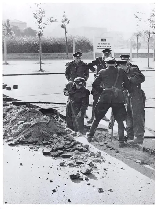 Berlin Wall Photo -  Date - Possibly August 1961 - East German Police Tear Up Pavement Near Potsdamerplatz to Build Permanent Road Block. Communist Erected Sign In Background Reads: 'You Are Entering Democratic Berlin.'. 