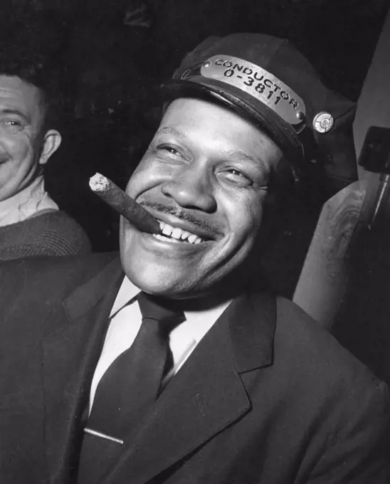 A New York Subway conductor enjoys a cigar in a crew recreation room. The wage of a first year conductor is $1.10 per hour for a forty-eight hour week. On the side of his cap he wears his union button signifying membership in the Transport Workers Union of the Congress of Industrial Organizations (CIO), New York, NY, 1948. (Photo by United States Information Agency/GG Vintage Images) 