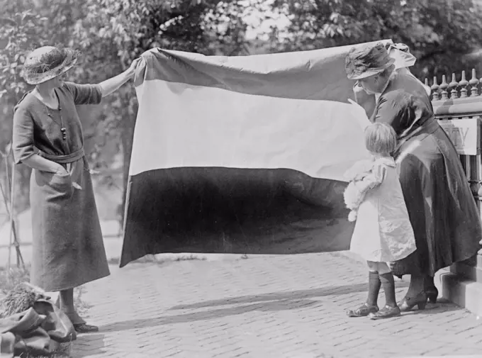 Two suffragettes showing banner to young girl ca. between 1910 and 1930.