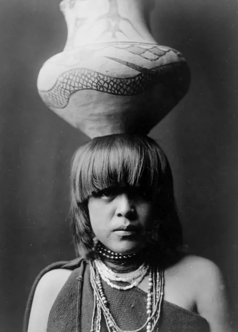 Edward S. Curits Native American Indians - San Ildefonso girl with large jar balanced on her head ca. 1927. 