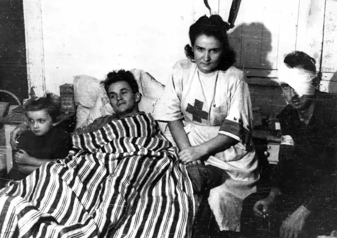 Warsaw Uprising: Nurse Janina St?czniewska 'Inka' with daughter Hania and wounded insurgent Edmund Michniewski 'Mi?' in the hospital of 'Koszta' Company ca. August 1944. 