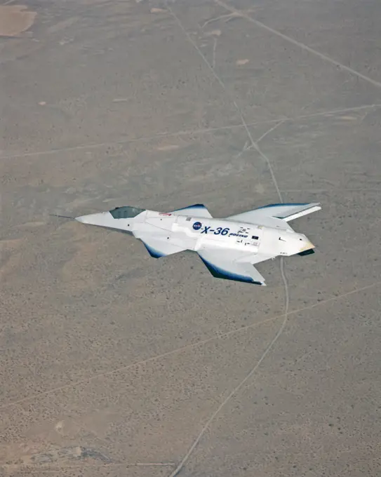 The tailless X-36 technology demonstrator research aircraft cruises over the California desert at low altitude during a 1997 research flight.. 