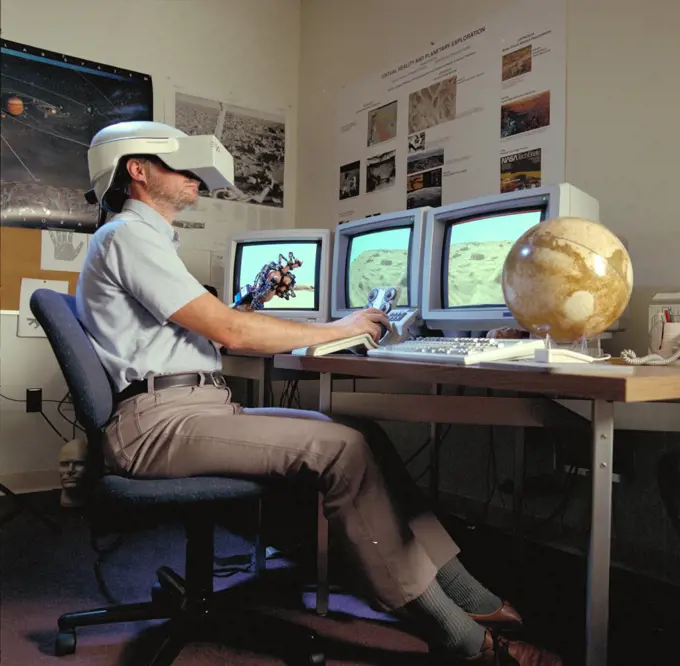Virtual Environment Telepresence workstation, simulated Mars Exploration shows Lewis Hitchner with virtual helmet and EXOS Dexterous interface (virtual hand). 