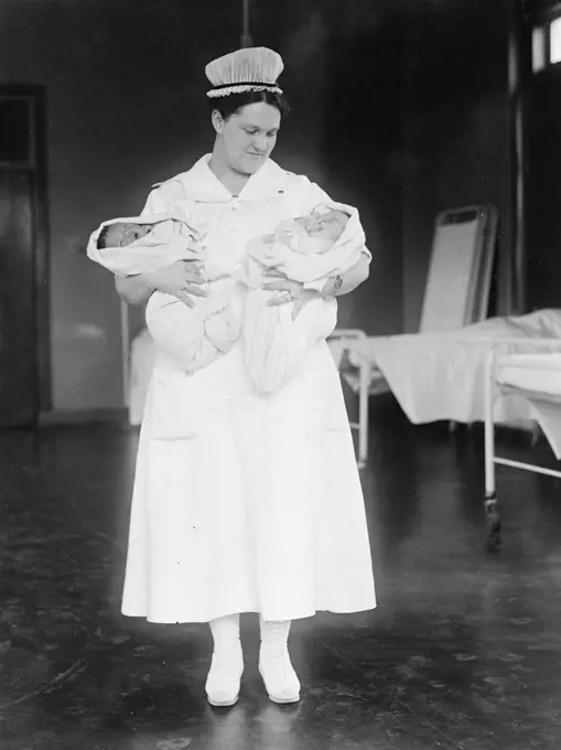 Nurse holding two babies ca. 1916-1919