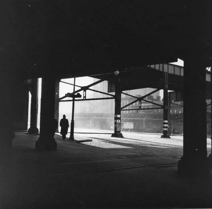 A moody scene of man walking in shadows along the waterfront, New York, NY, 1/3/1937. (Photo by David Robbins/Works Projects Administration/GG Vintage Images/UIG)