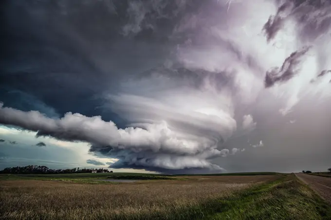Tornado warned storm with lightning flashing over field in rural southern Saskatchewan Canada