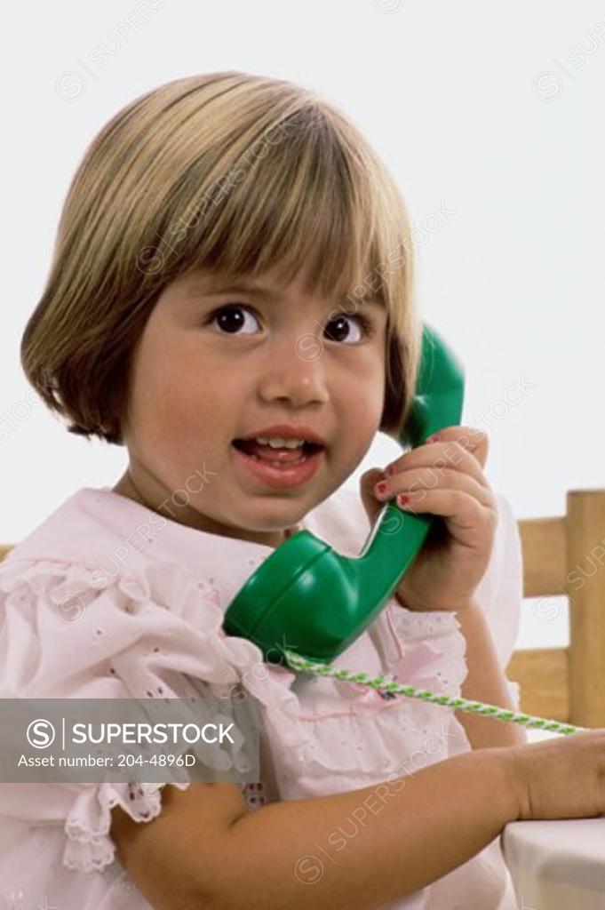 Stock Photo: 204-4896D Portrait of a young girl holding a telephone receiver