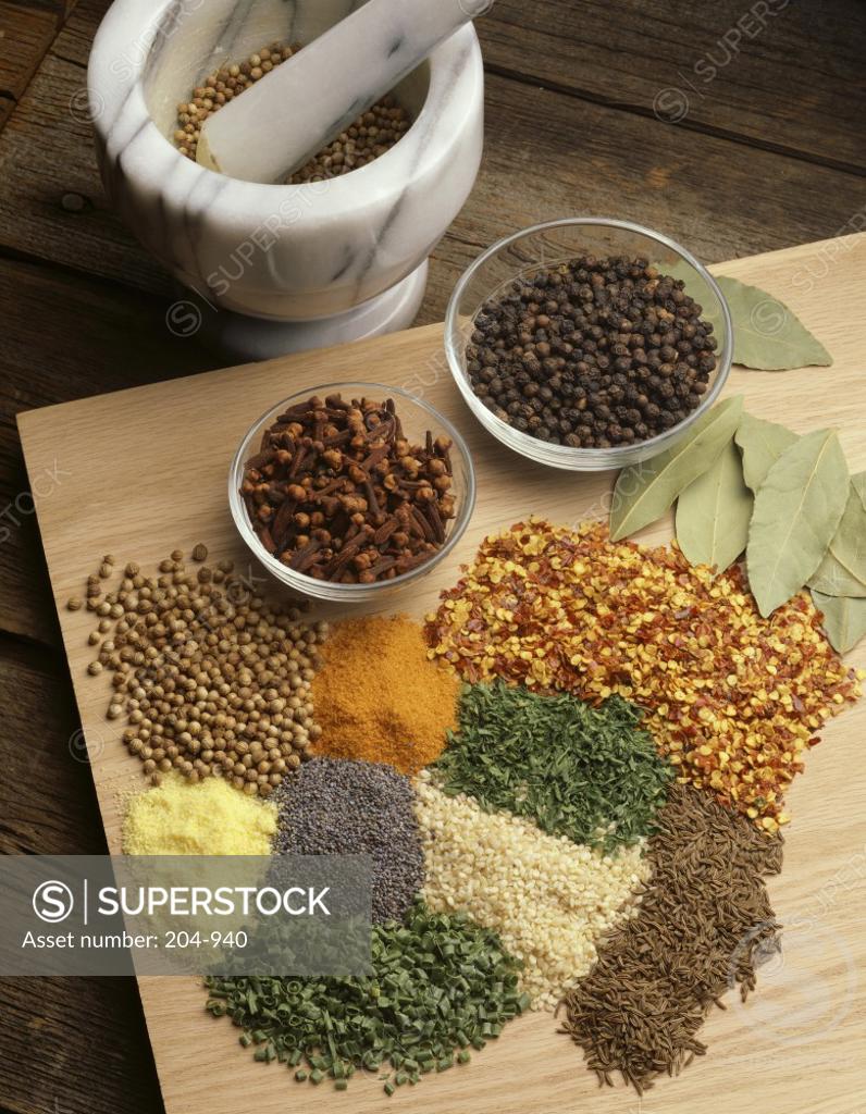 Stock Photo: 204-940 High angle view of spices on a cutting board with a mortar and pestle