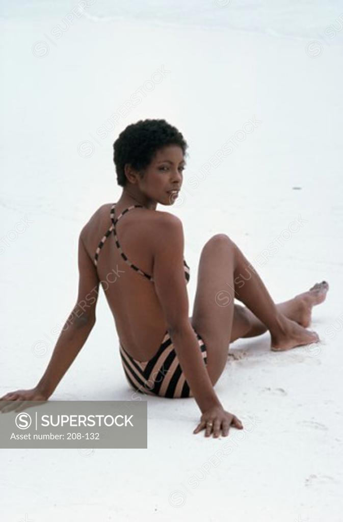 Stock Photo: 208-132 Rear view of a young woman sitting on the beach