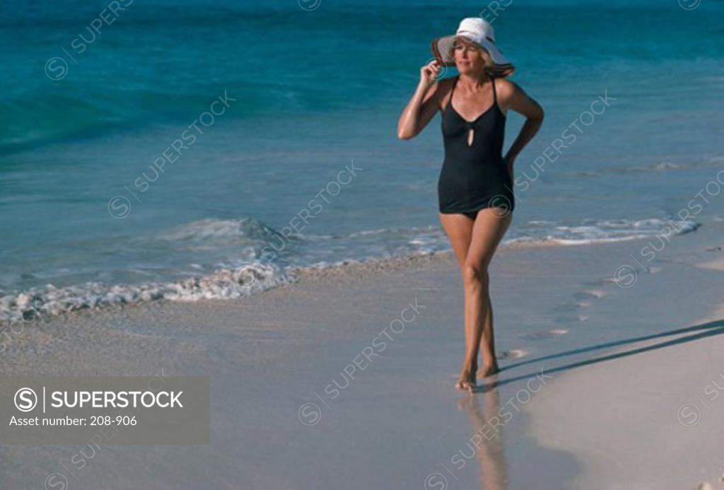 Stock Photo: 208-906 Mature woman strolling on the beach