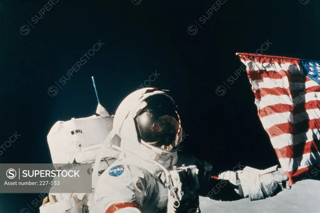 Eugene Cernan, Commander of Apollo 17, adjusts his flag on Taurus-Littrow, Taken by Harrison Schmitt, December 1972