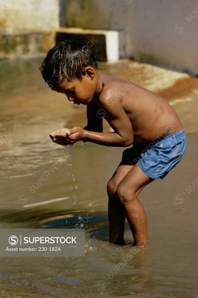 Stock Photo: 230-182A Boy cupping water from sea