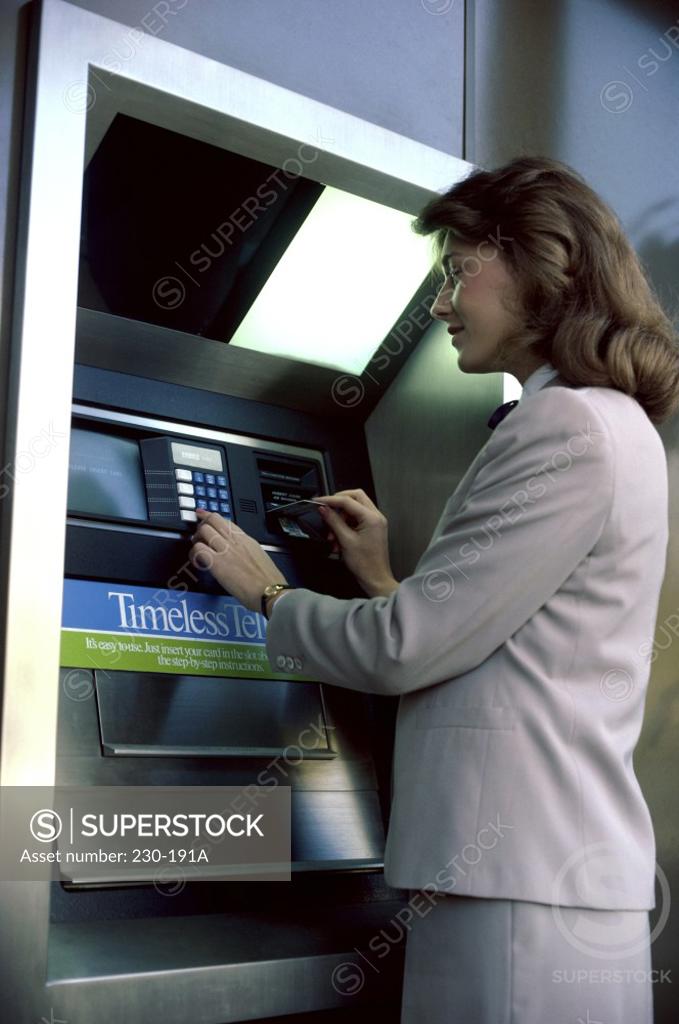 Stock Photo: 230-191A Businesswoman operating an ATM
