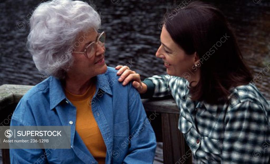 Stock Photo: 236-129B Close-up of a young woman with her mother sitting on a bench and talking
