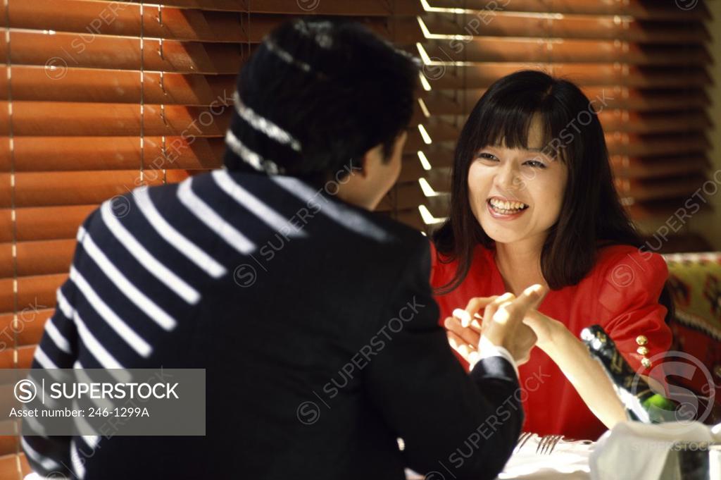 Stock Photo: 246-1299A Rear view of a young man holding a young woman's hand in a restaurant