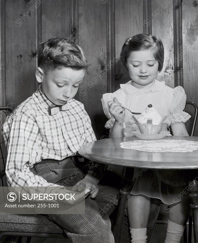 Stock Photo: 255-1001 Boy and a girl sitting at a table in a restaurant